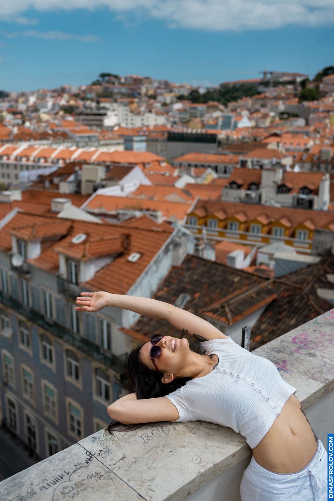 Woman relaxes with a view of Lisbon-s rooftops. Alfama district, Portugal. Travel photography.