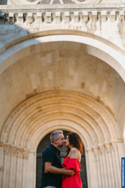 Couple kissing in Lisbon, Portugal, with a stone archway backdrop. Romantic moment in Europe.