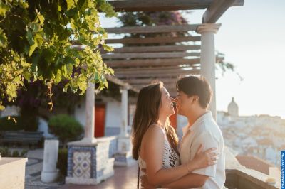 Couple embracing in Lisbon, Portugal. Romantic moment with city view, tiles, and pergola. Travel photography.