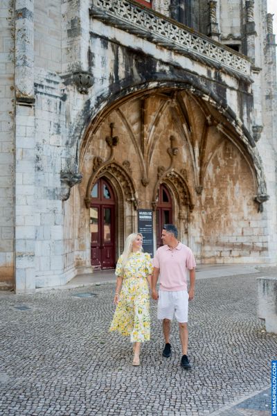 Couple walking in Belem, Lisbon, Portugal. Museu de Marinha in background. Cobblestone street. Romantic travel.