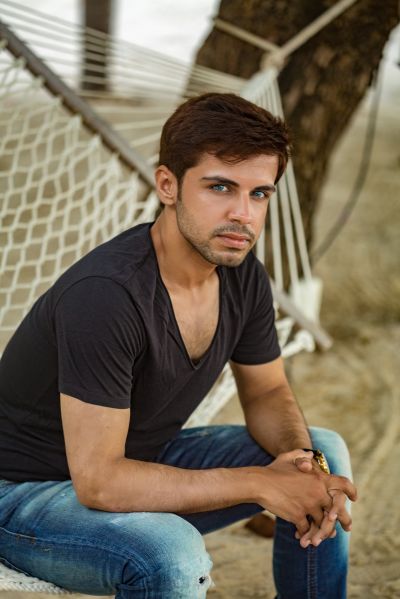 Man relaxing in hammock, Lisbon. Portrait of a stylish man in Portugal. Travel photography.