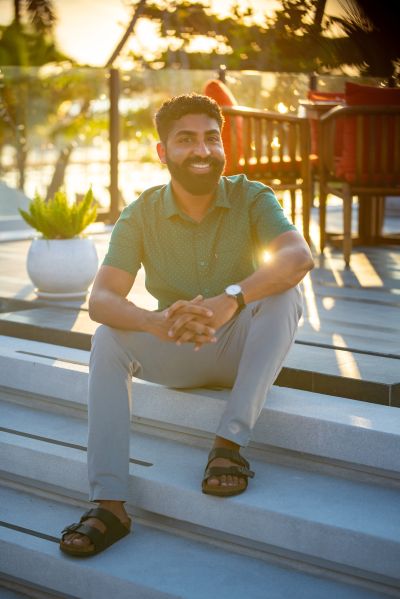 Man sits on steps in Lisbon. Smiling, casual, enjoying the golden hour. Lisbon vibes.
