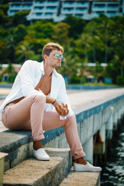 Stylish man in Lisbon, Portugal. Casual chic look with sunglasses. Coastal view.