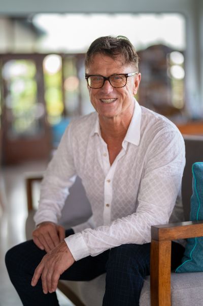 Man in Lisbon. Portrait of a smiling man with glasses, seated indoors. Lisbon vibes.