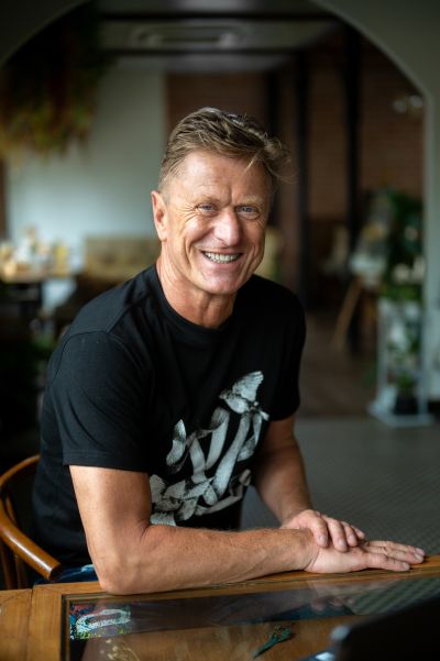 Smiling man in Lisbon cafe. Portrait of a man with blue eyes in a black t-shirt sitting at a table. Lisbon, Portugal.