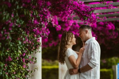 Romantic couple in Lisbon, Portugal, under vibrant bougainvillea. Love, travel, and Portuguese charm.