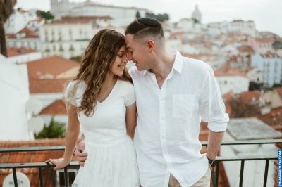 Couple in Lisbon. Romantic moment overlooking the Alfama district with its red rooftops and historic buildings.