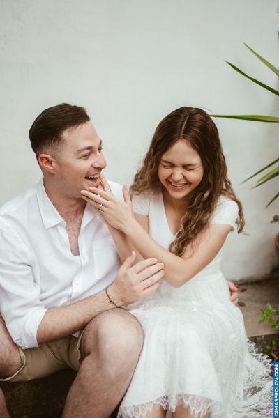 Lisbon Engagement: Happy couple laughing, showing ring. Romantic moment in Portugal.