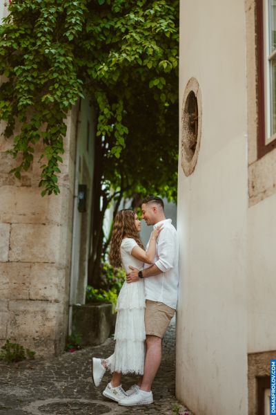 Couple in Lisbon, Portugal. Romantic moment in a charming alley with stone walls and lush greenery. Lisbon romance.