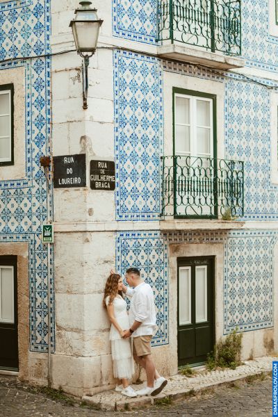 Couple in Lisbon, Portugal. Traditional blue & white tiled building, Rua do Loureiro. Romantic scene.