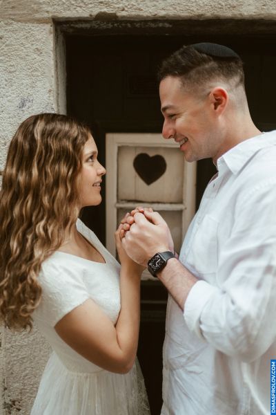 Romantic couple holding hands in Lisbon. Heart detail on door. Love in Portugal, wedding vibes.