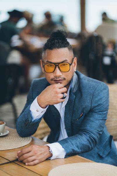Stylish man with yellow glasses in Lisbon. Blue suit, modern hair. Lisbon cafe scene. Men-s fashion.