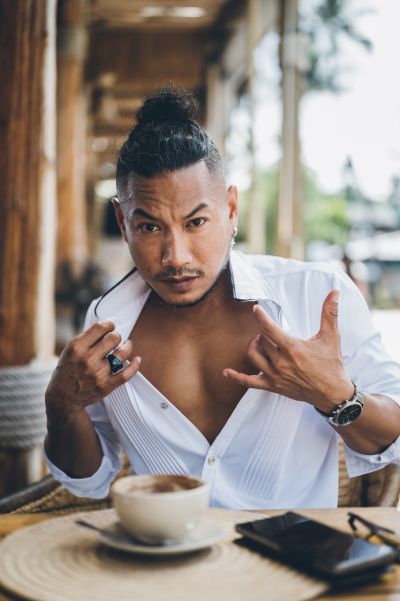 Stylish man with coffee in Lisbon. White shirt, modern bun hairstyle. Alfama vibes. Portugal travel.
